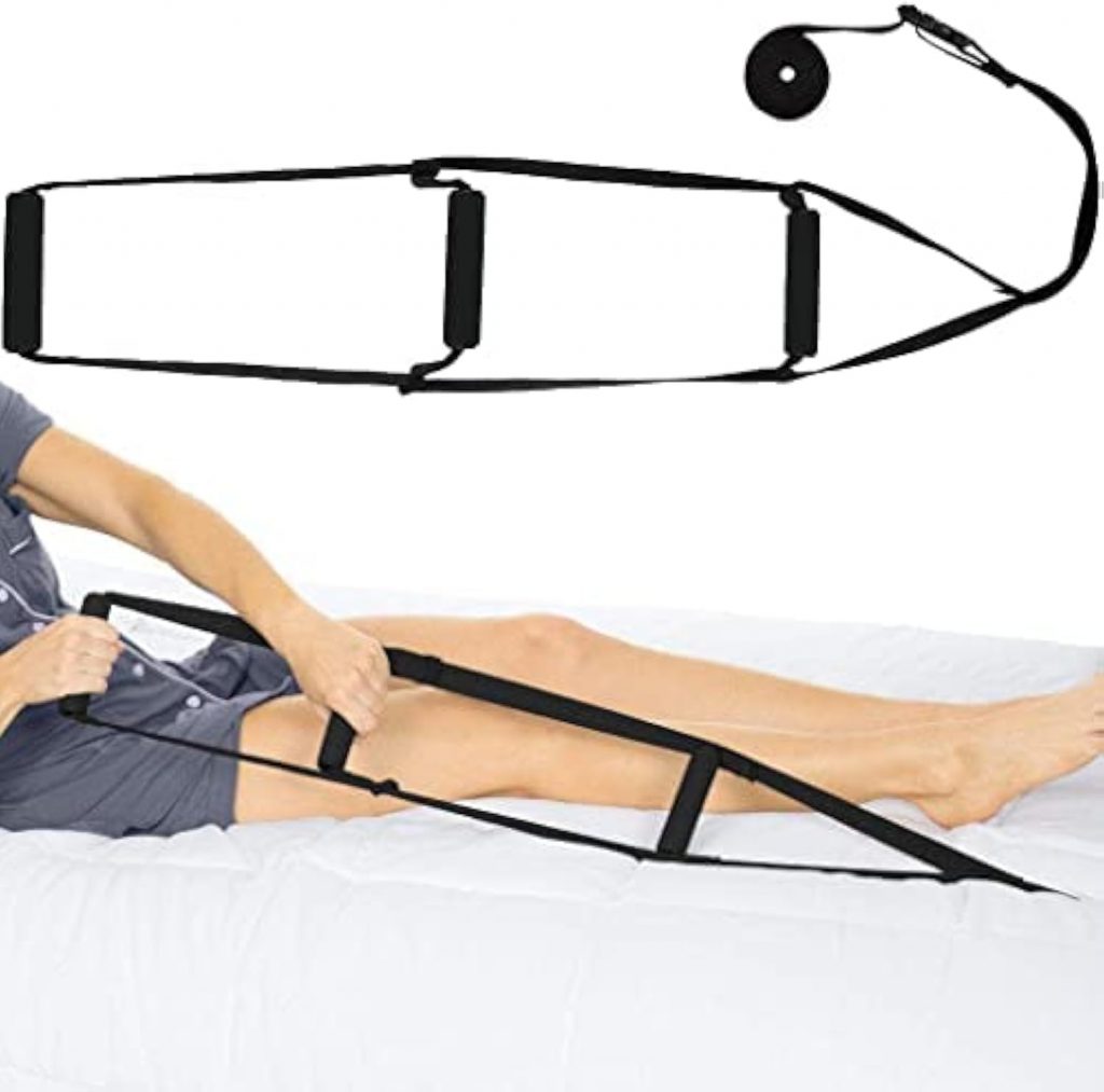 A woman lying on a bed demonstrates the use of a leg lifter strap to assist with moving her leg. She is wearing a gray button-up shirt and is holding the strap's handles to lift her leg. The strap, designed for mobility assistance, is shown separately at the top of the image to highlight its full structure. The bed features a plain white sheet, providing a clean background for the demonstration. How to Sleep After a C-Section - EquipMeOT